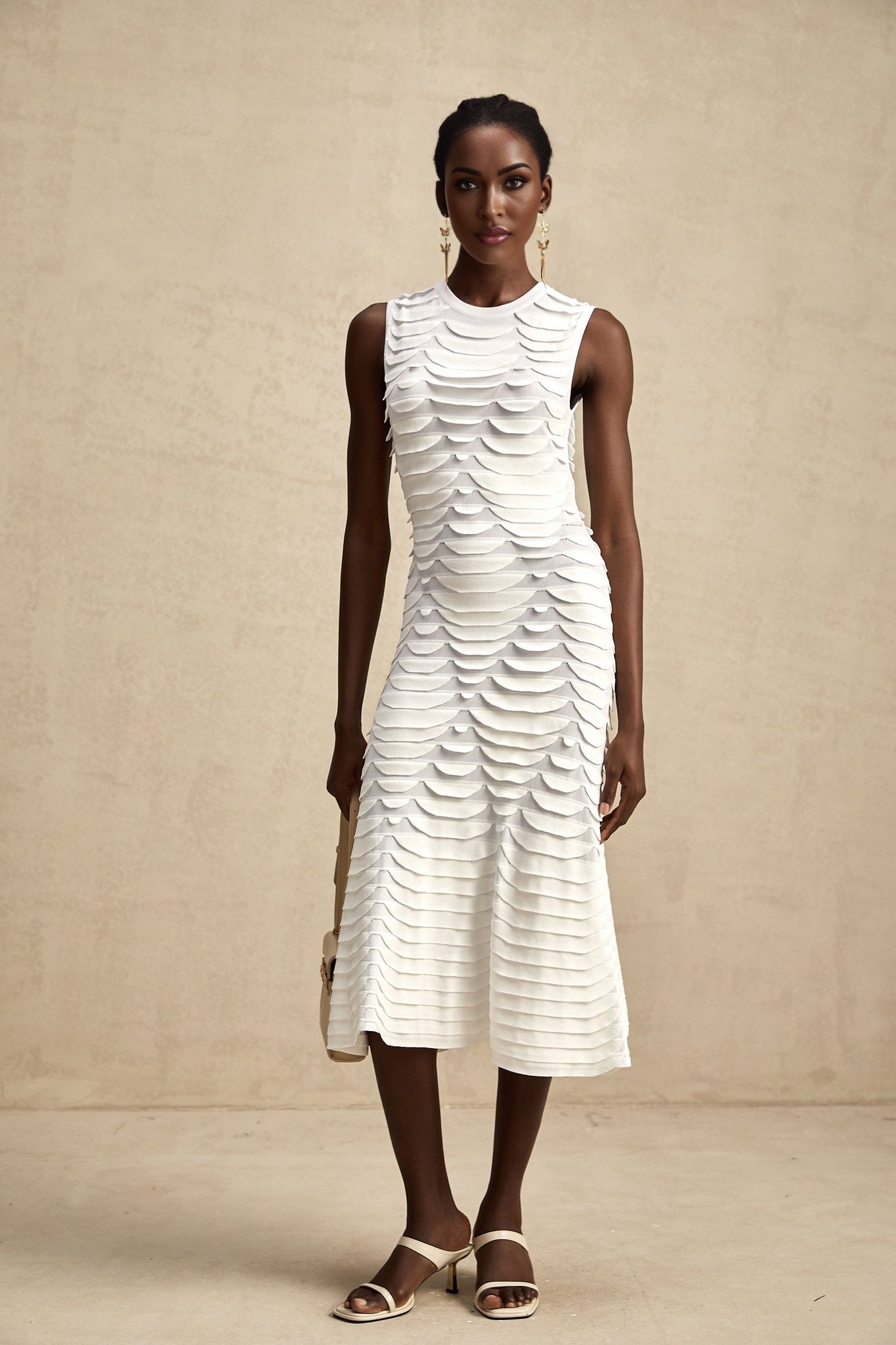 Woman wearing a midi length dress with snake pattern print and godet skirt detail