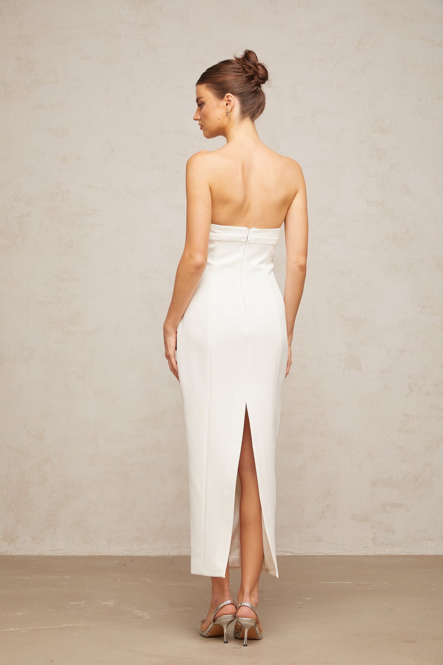 A white midi dress with corset styling and bow details named Isaline