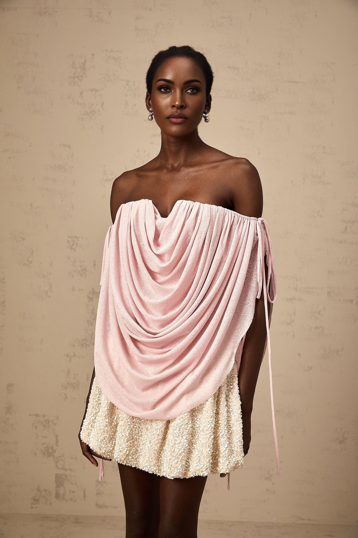 Woman wearing a pink offshoulder top with ruched detailing