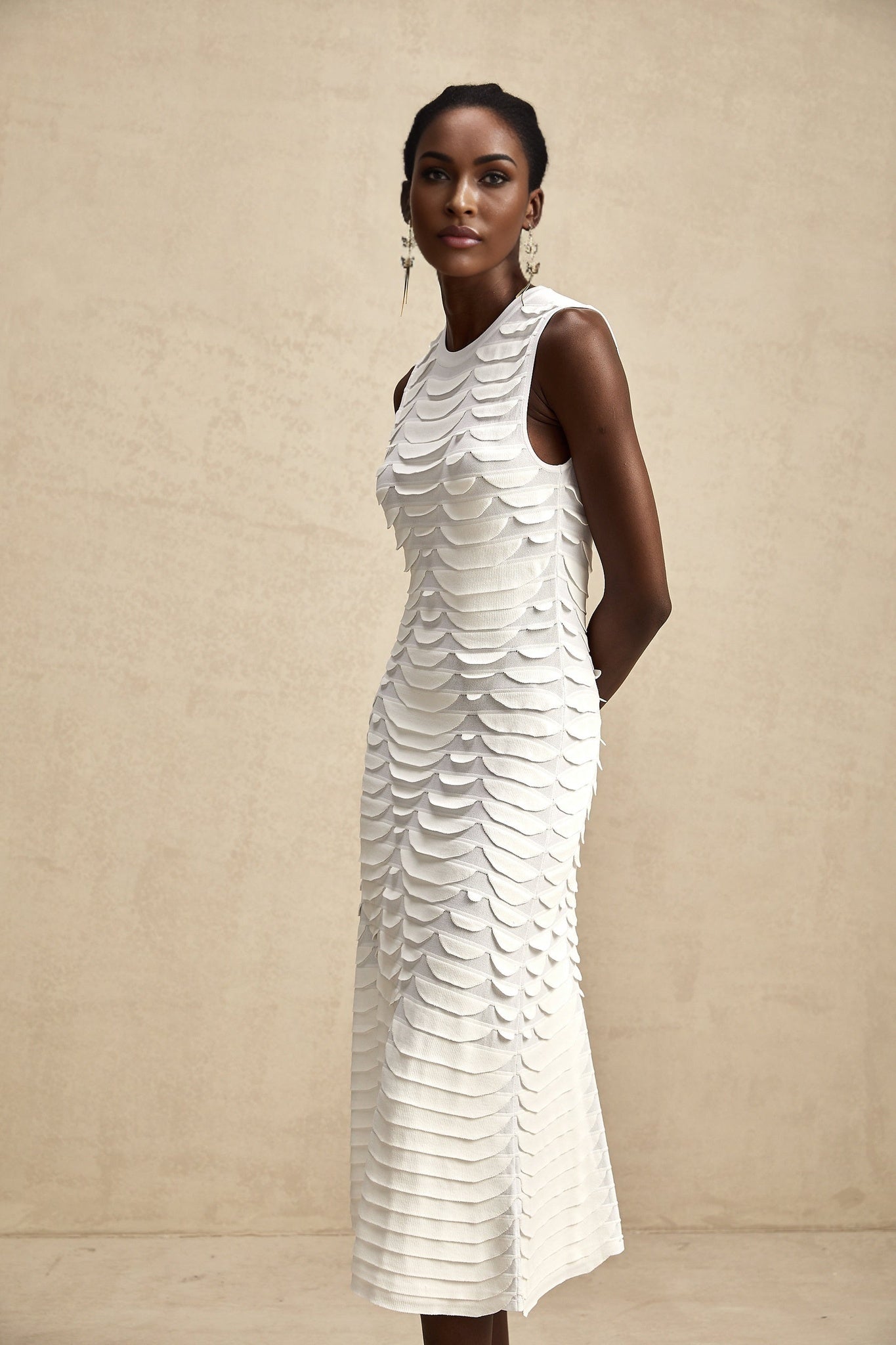 A woman wearing a midi length dress with a snake pattern print and godet flared skirt