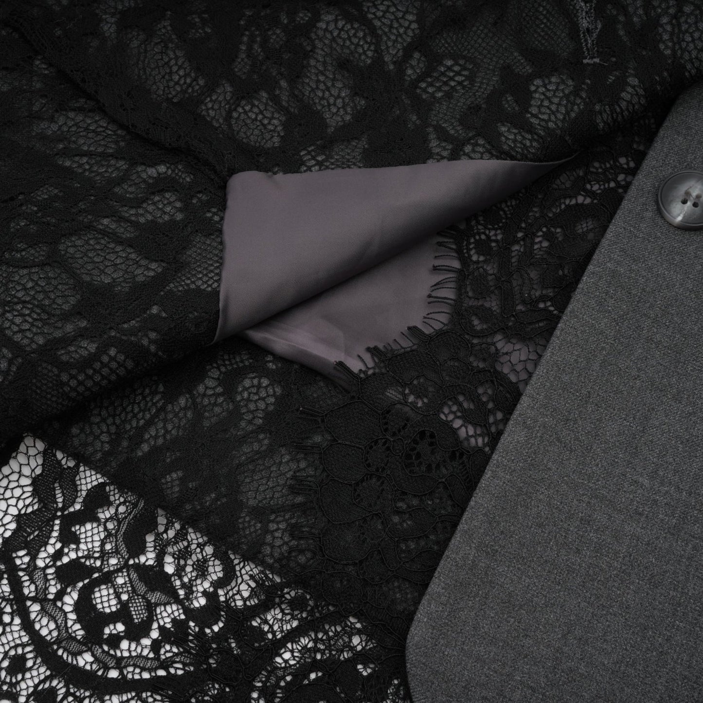 Woman wearing grey blazer with lace panel details on sleeves and back