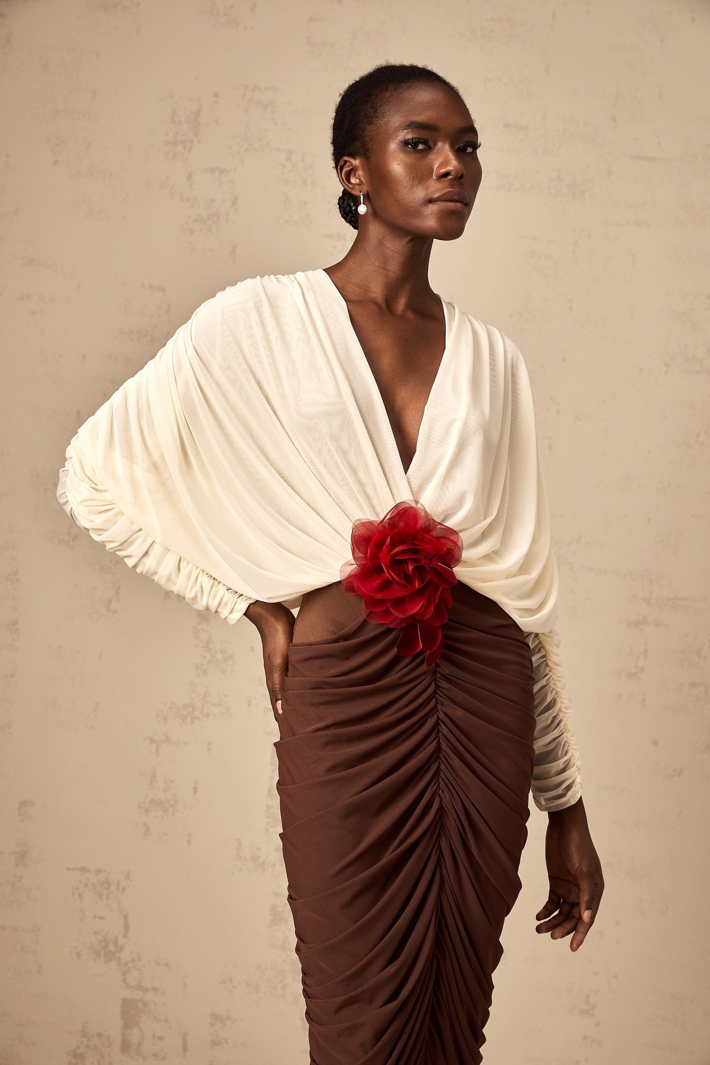 A midi dress with ruched detailing featuring colorblocked sections and a decorative flower brooch The dress is named Leontine and appears to be a stylish womens garment