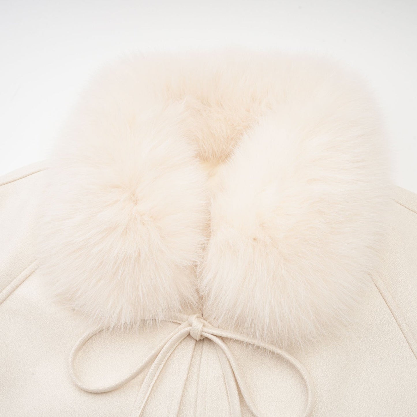 A white short coat made of suede with fur padding and a padded design featuring the name Cecile