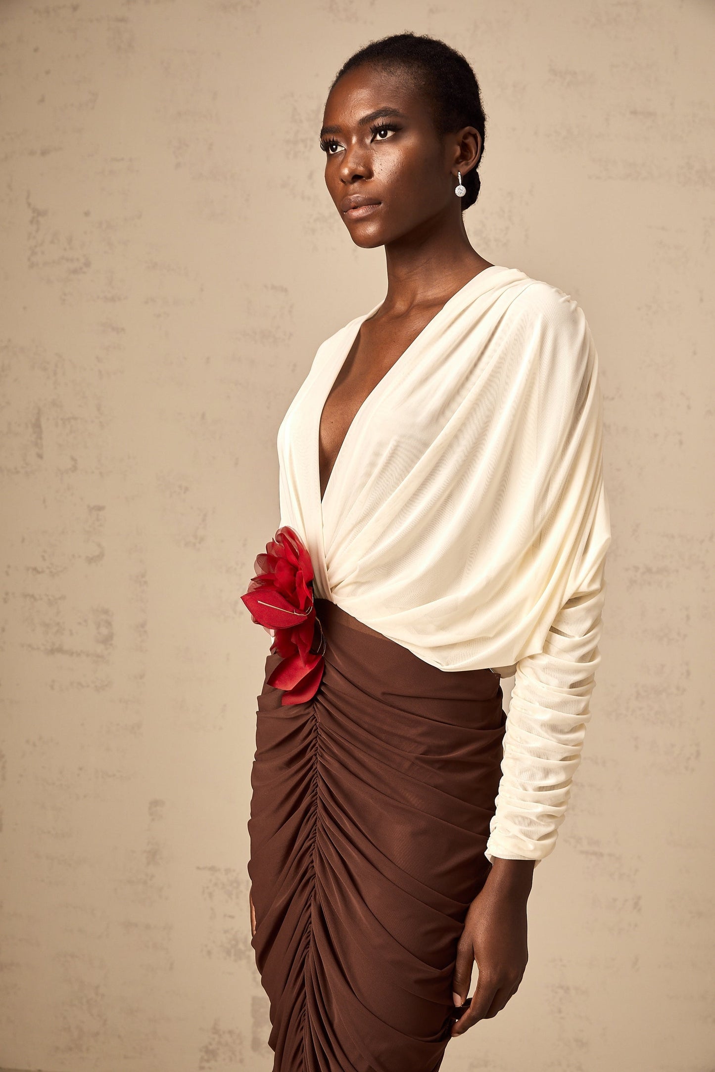 A colorful midi dress with a ruched design featuring a flower brooch and color blocking named Leontine