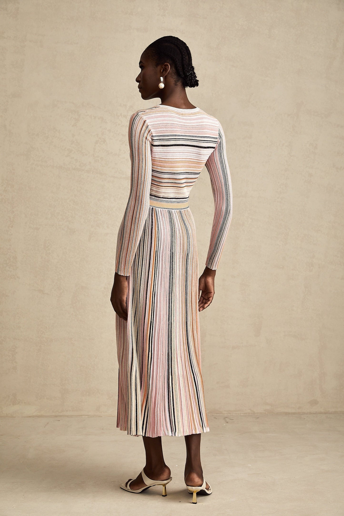 A pink metallic midi dress with pleated fabric named Mathilde featuring a shimmery finish and flowing design