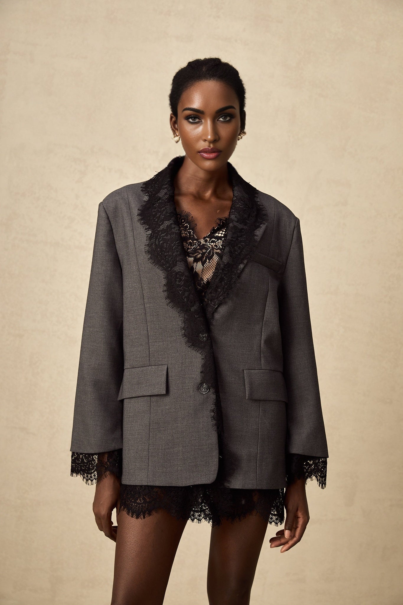 Woman wearing grey blazer with lace panel detailing