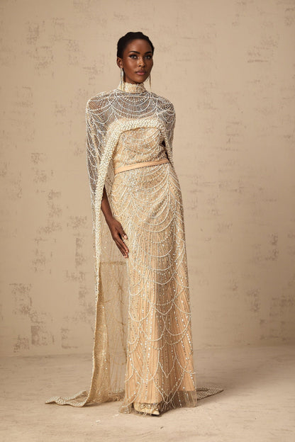 Woman wearing long champagne gown with matching beaded cape elegant formal dress ensemble