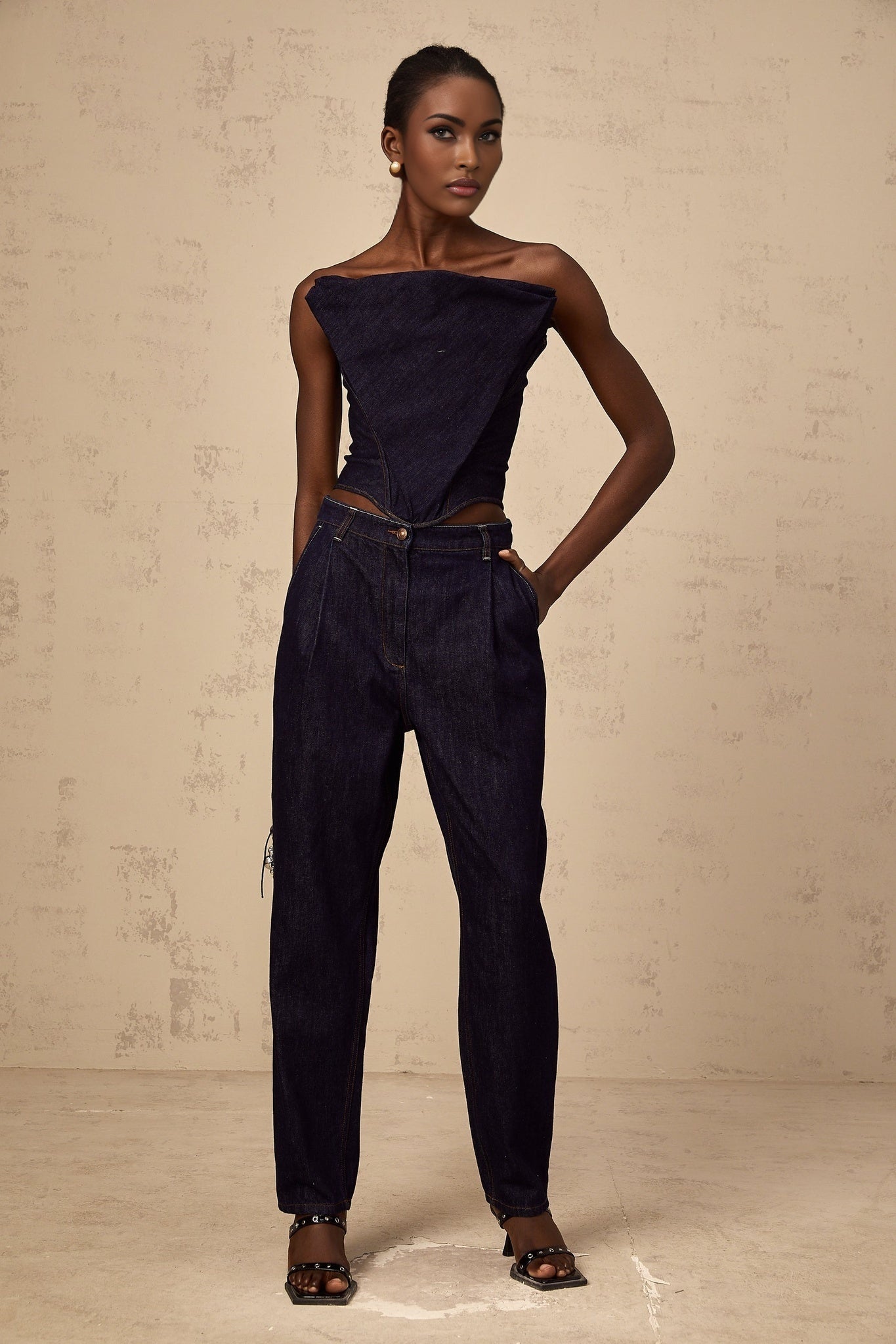 A dark blue offshoulder denim top from Kleber worn by a model against a plain background