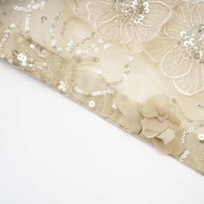 A woman wearing a sheer floral jacket with beaded embellishments and delicate organza fabric in a light luxurious style