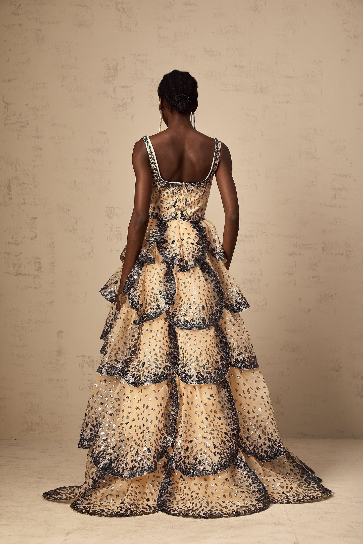 A long tiered maxi dress with sequined petal details and a flowing silhouette