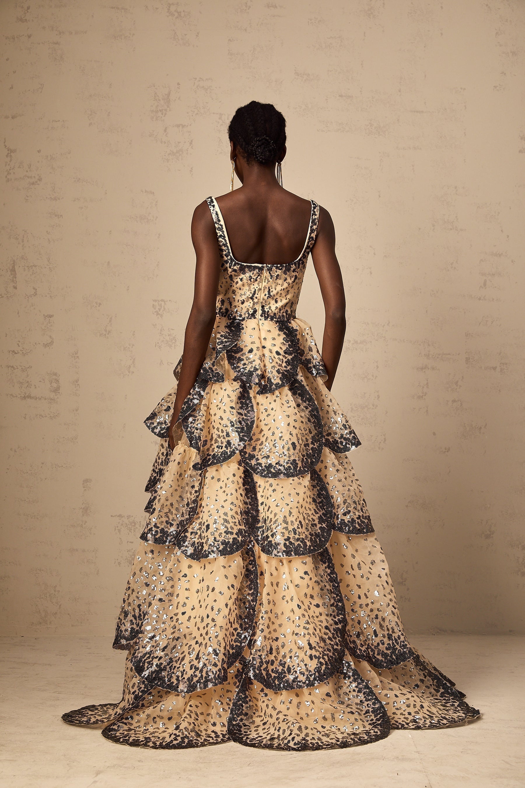 A long tiered maxi dress with sequined petal details and a flowing silhouette