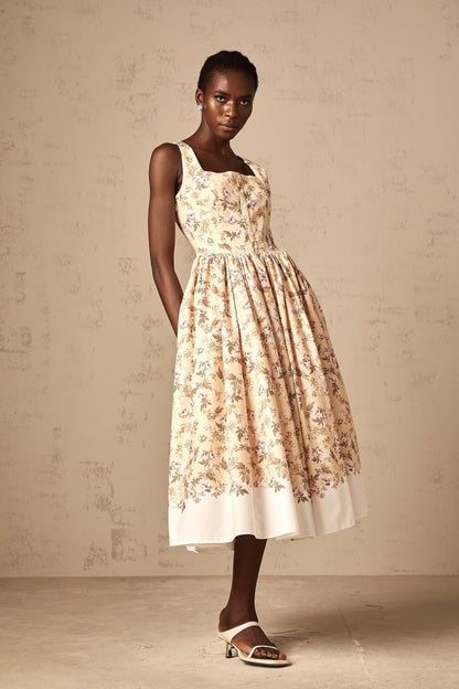 A yellow midi dress with a floral print pattern and buttons down the front