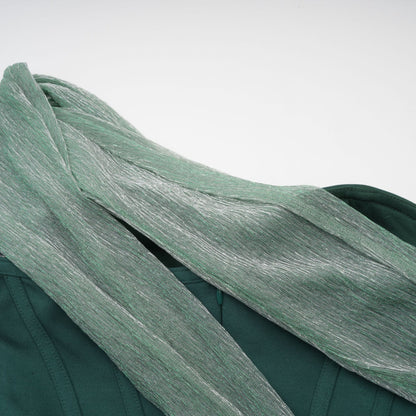 A green maxi dress with corset bodice featuring ribbon design details and long flowing skirt