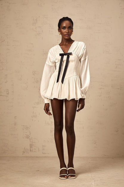 A white mini dress with a bowknot detail and glitter accents named Lina