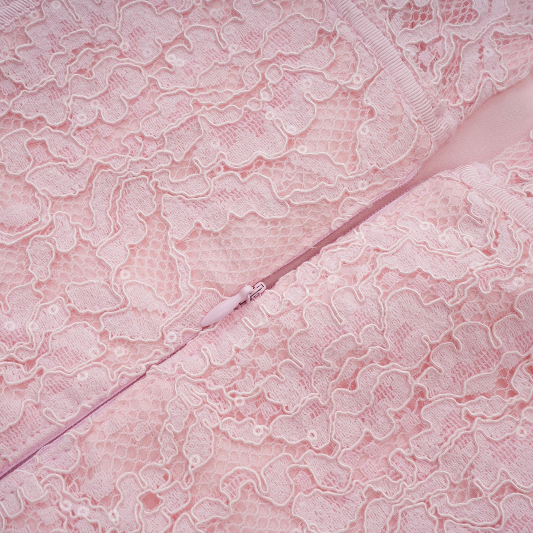 A pink midi dress with floral embroidery and lace details featuring embellishments and a feminine silhouette