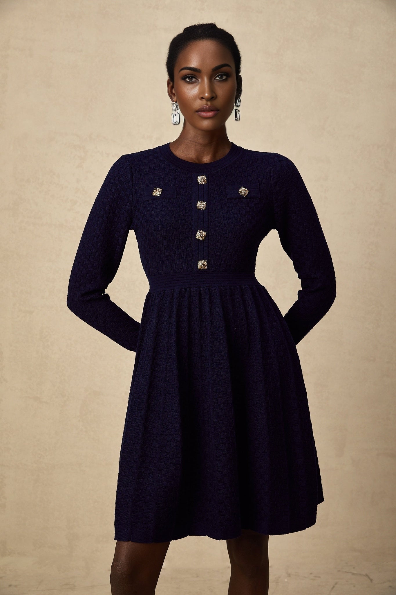 A navy blue mini dress with a basket weave pattern and short sleeves on a female model against a plain background