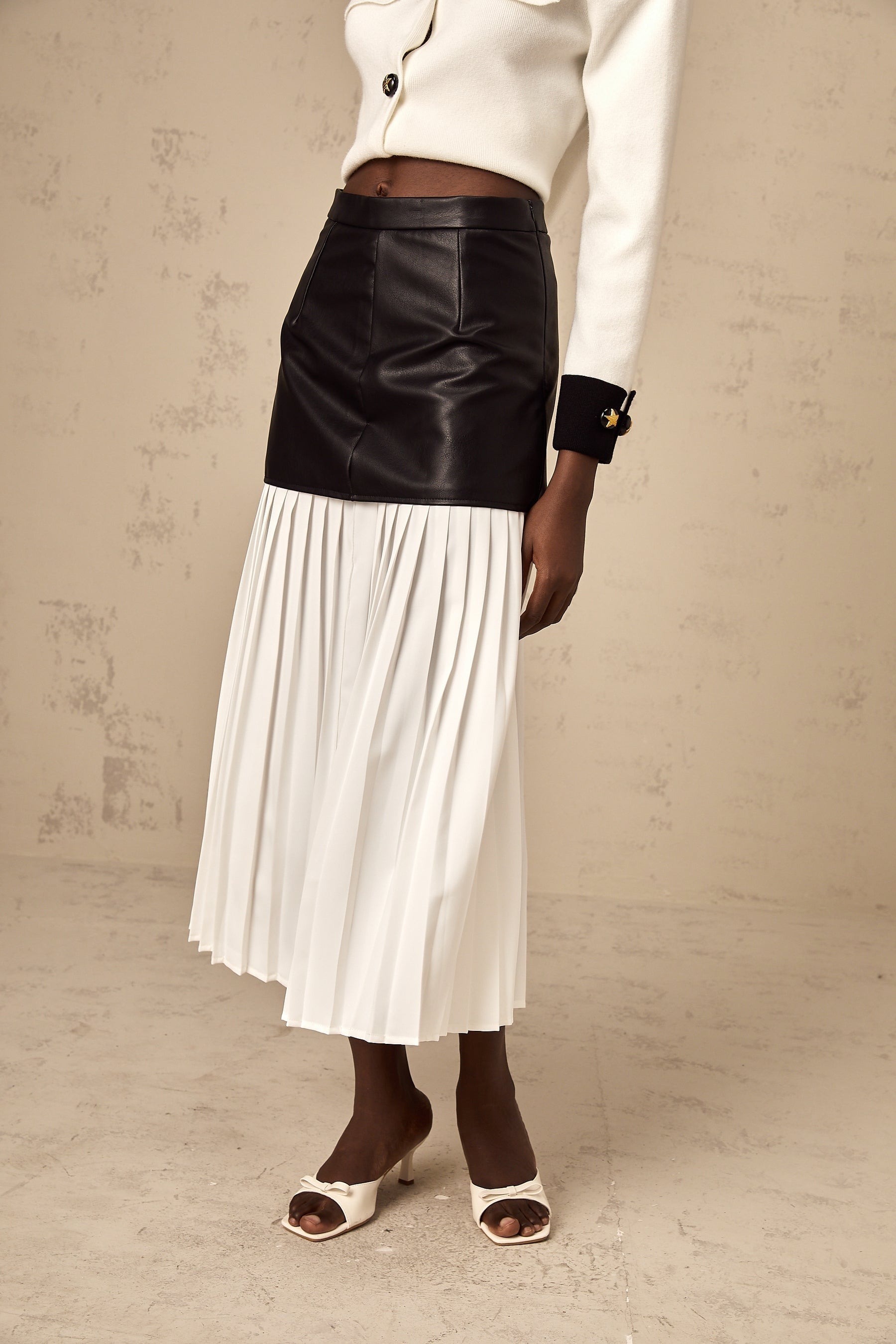 A midi skirt with colorblocked panels and pleated design featuring contrasting colors and a flowy silhouette