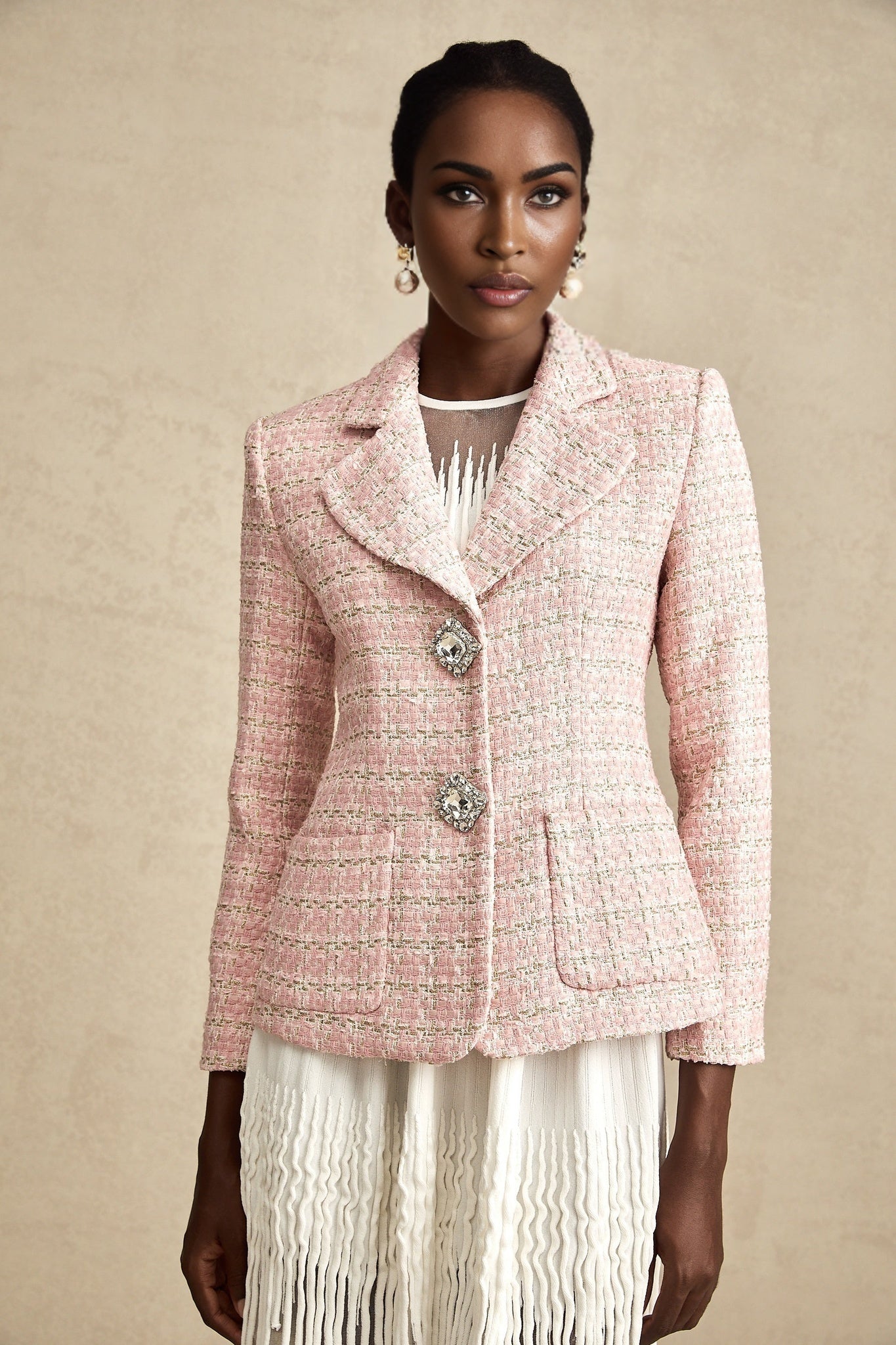 A pink blazer with crystal embellishments and a checked tweed pattern