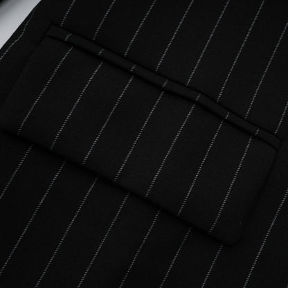 A black blazer with white stripes featuring an open back design worn by a model facing away from the camera