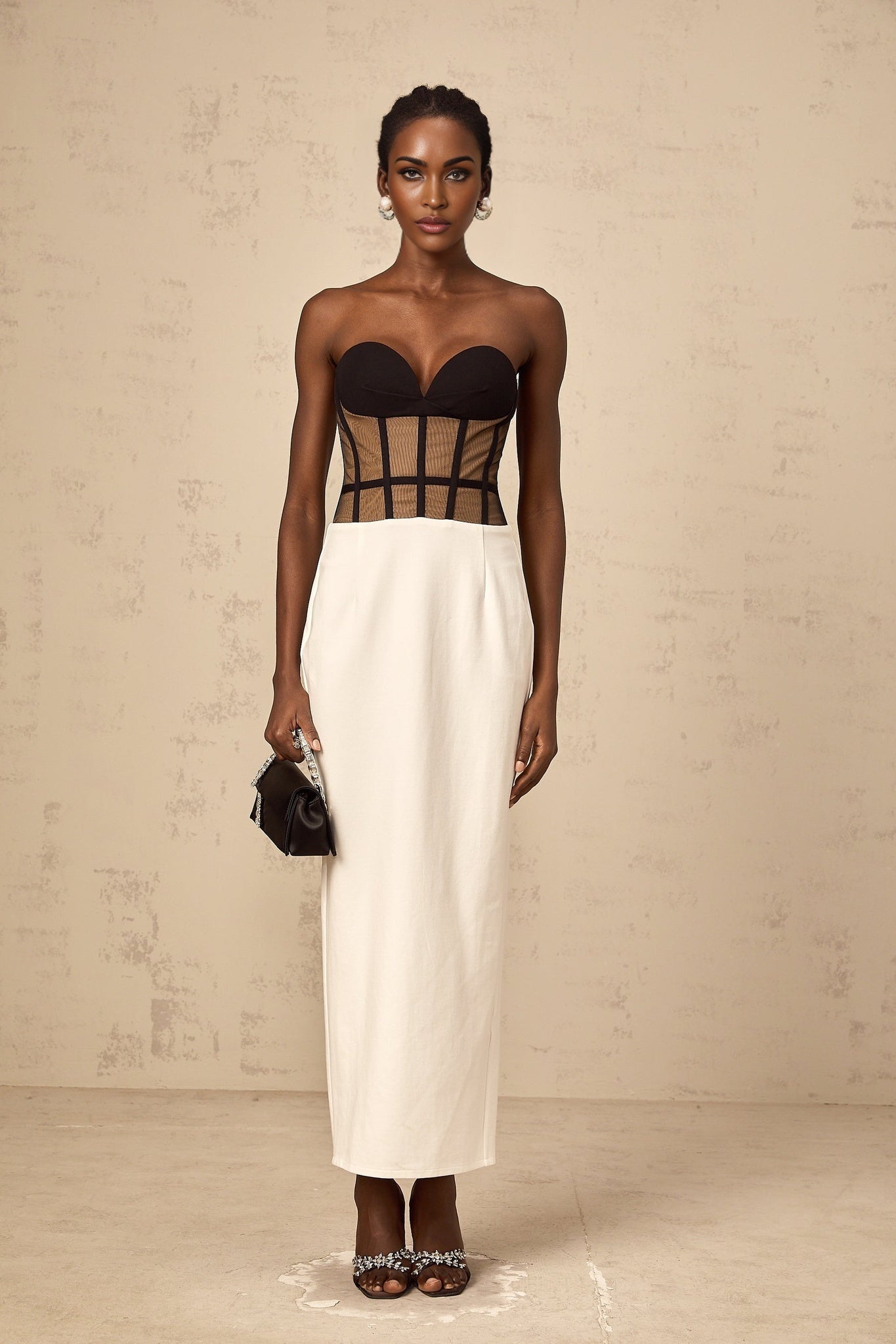 A long sheer maxi dress with a corset style bodice featuring contrasting colors and a flowing skirt