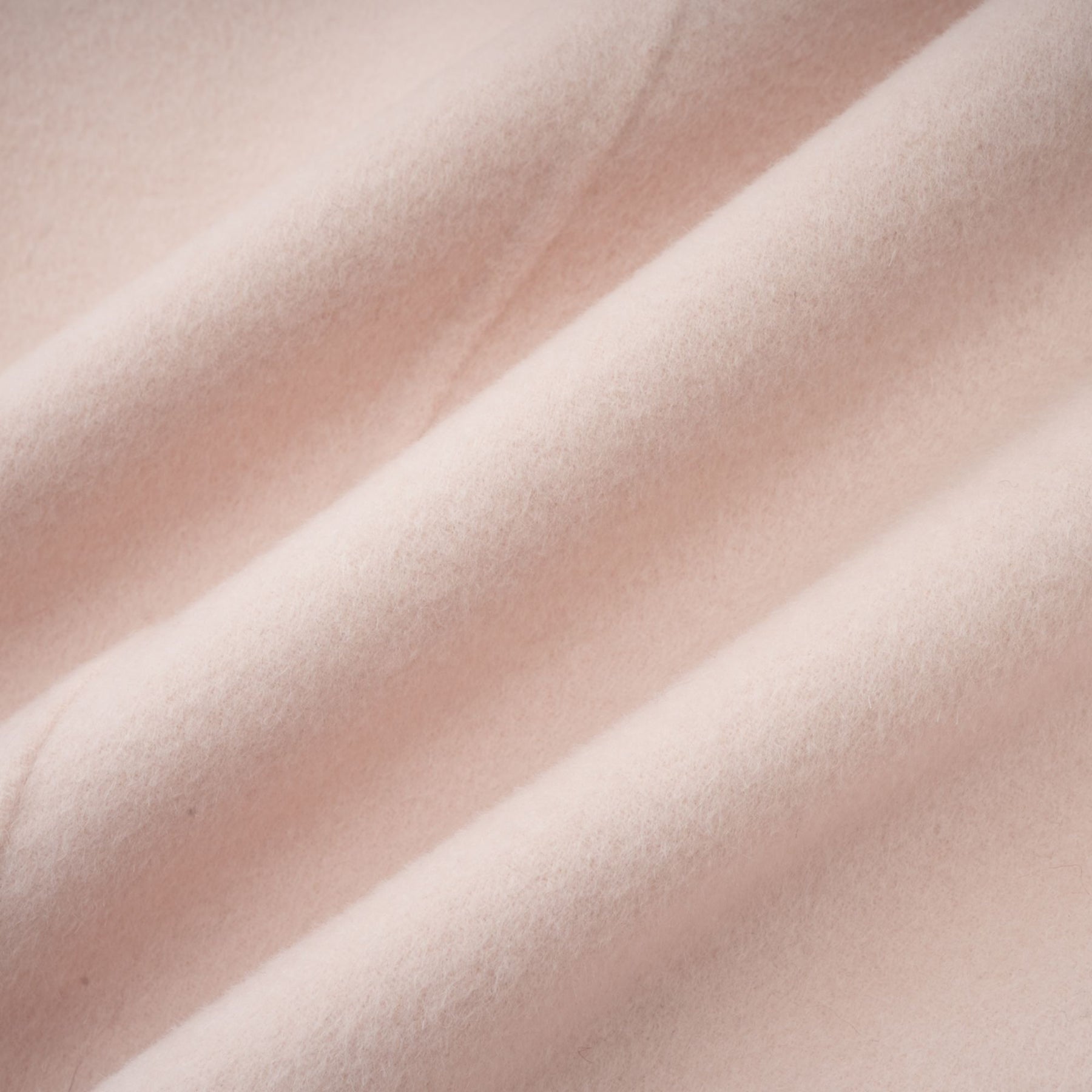 A pink short coat with a diagonal placket design called the Vienne featuring a sleek and modern style