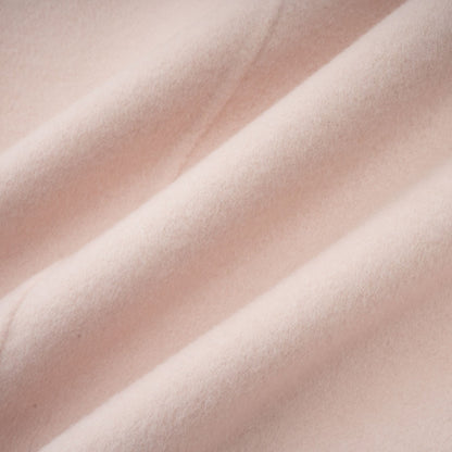 A pink short coat with a diagonal placket design called the Vienne featuring a sleek and modern style