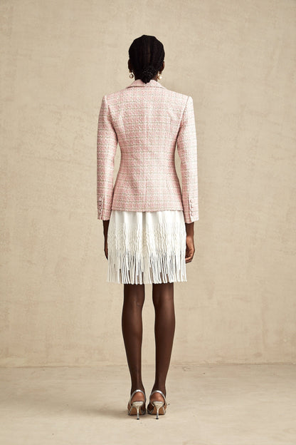 Woman wearing pink tweed blazer with crystal embellishments and check pattern