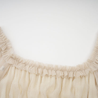 Woman wearing a shimmering pleated midi dress with shirred detailing and metallic finish in a soft flowing silhouette