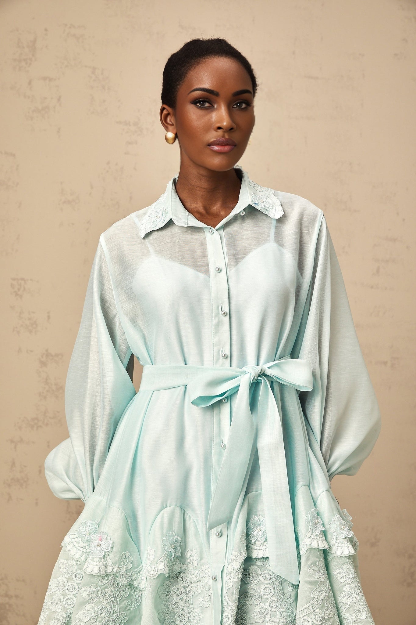 A short green mini dress with lace panel details and a shirt collar design