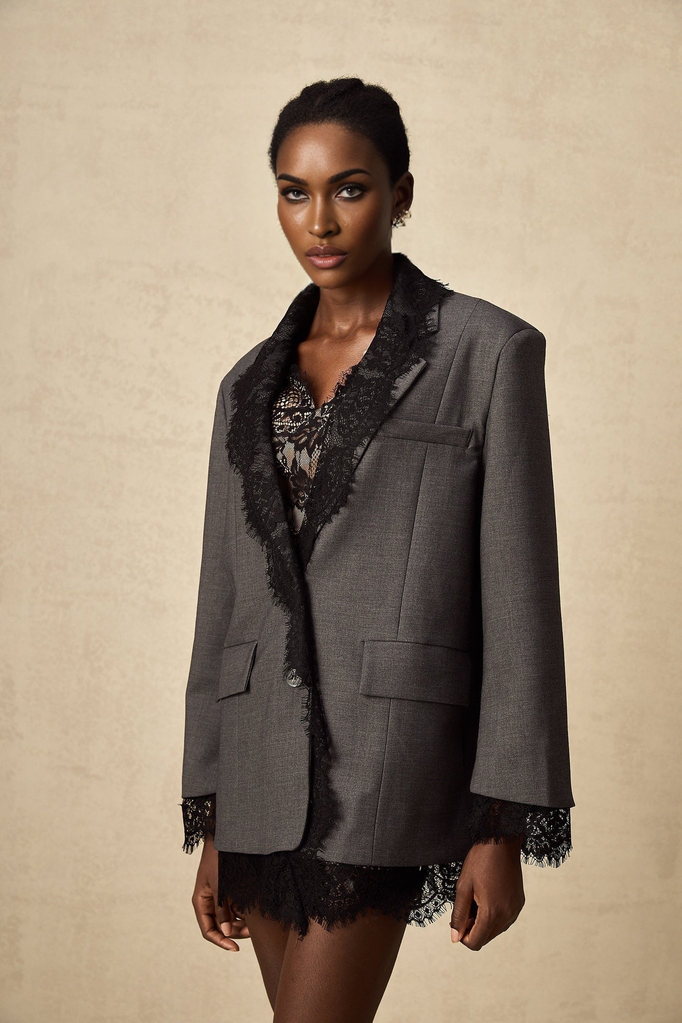 Woman wearing grey blazer with lace panel detailing