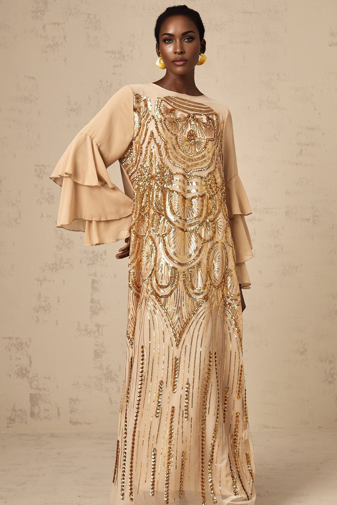 A long elegant maxi dress with ruffle sleeves and sequin embellishments on tulle fabric