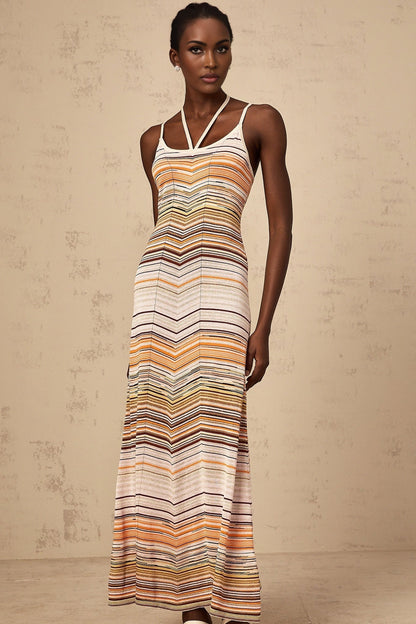 A long sleeveless knit dress with vertical multicolored stripes in pastel shades featuring a fitted bodice and flowing maxi skirt