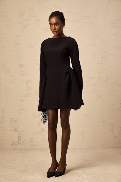 Woman wearing a black longsleeve mini dress with a flared skirt