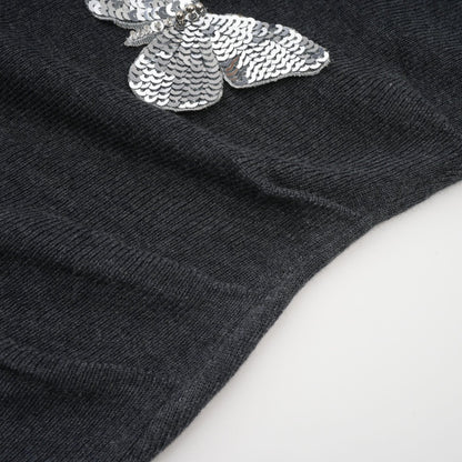 A grey cardigan with sequined butterfly designs adorning it