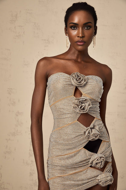A short black mini dress with rhinestone embellishments and strategically placed cutouts featuring a fitted silhouette and sleeveless design