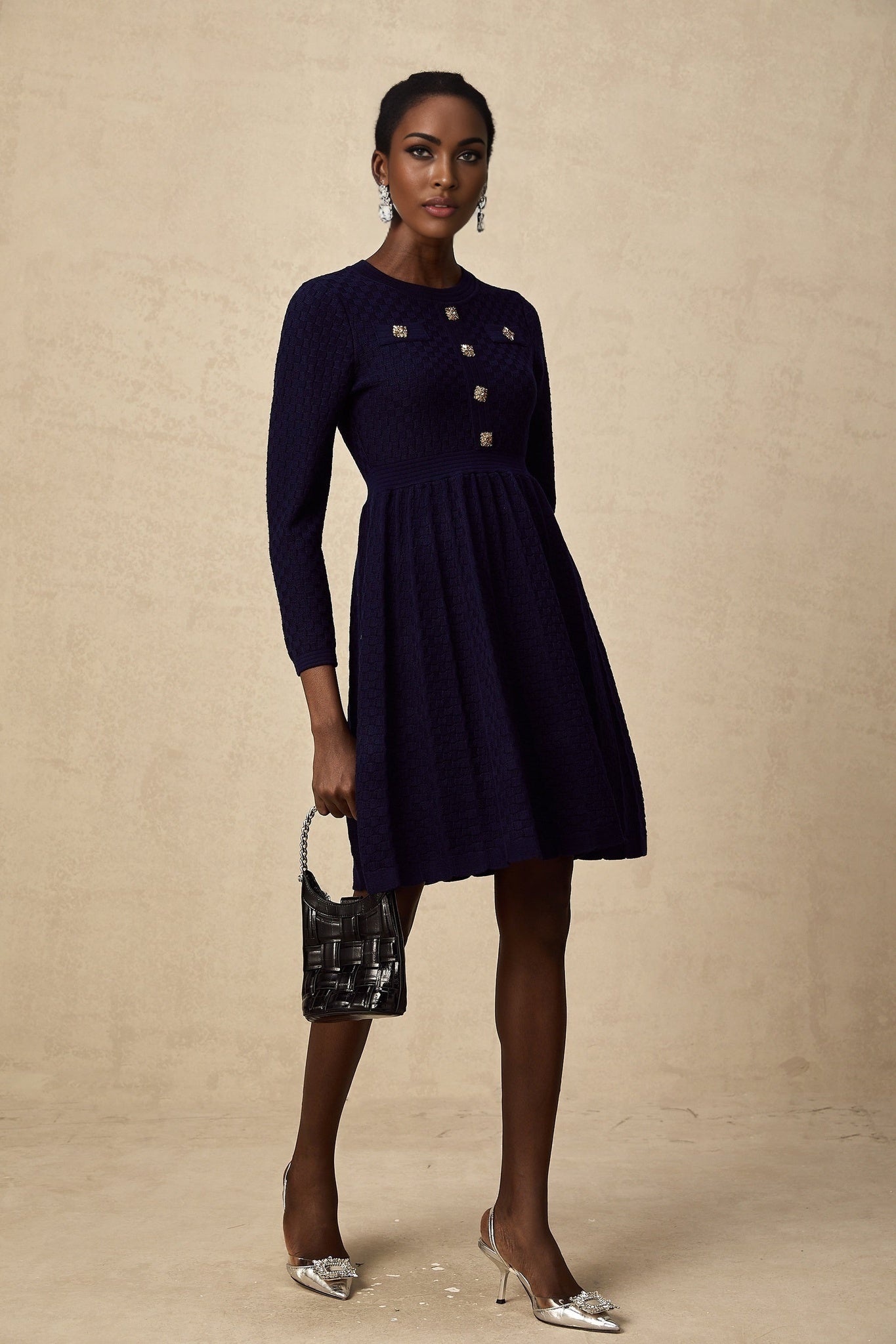 A navy blue mini dress with a basket weave texture and short length featuring a fitted silhouette and sleeveless design