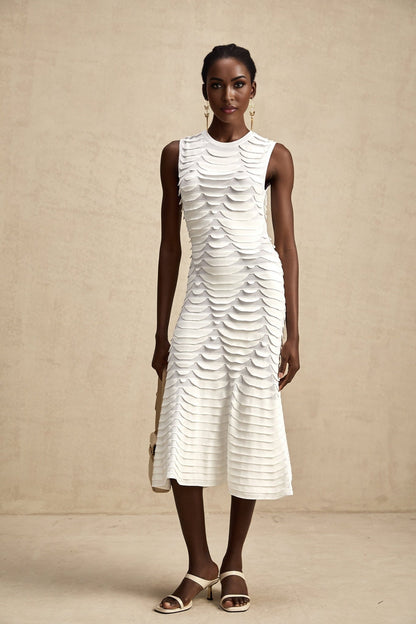 Woman wearing a midi length dress with snake pattern print and godet skirt detail