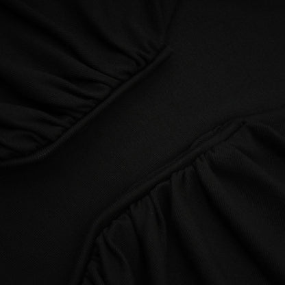 A black sleeveless top with an open front design and gathered fabric details