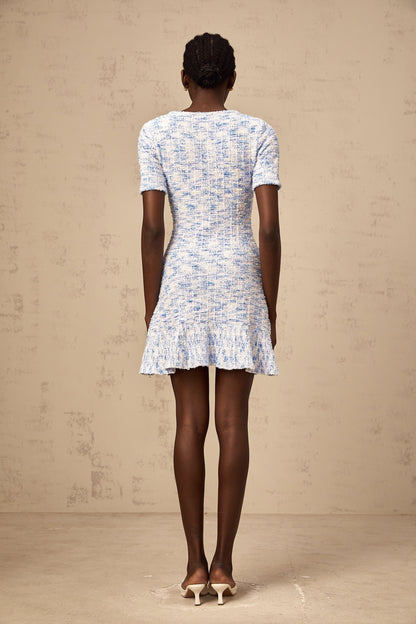 Young woman wearing a blue checked knit mini dress with short sleeves and a fitted silhouette