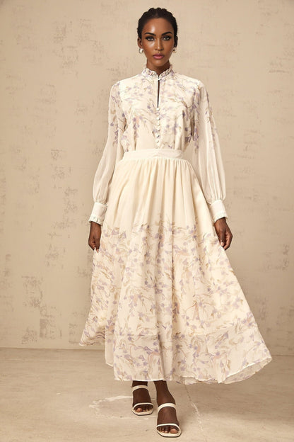 A woman wearing a matching floral set consisting of a frilled shirt and skirt in wisteria print with a Siena style