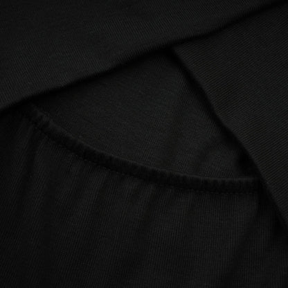 A black ruched top with long sleeves made of stretchy jersey fabric called Odette