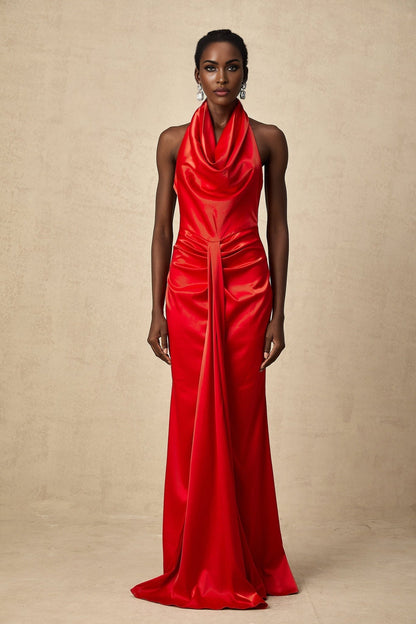 Woman wearing a long red satin maxi dress with halter neckline and draped design