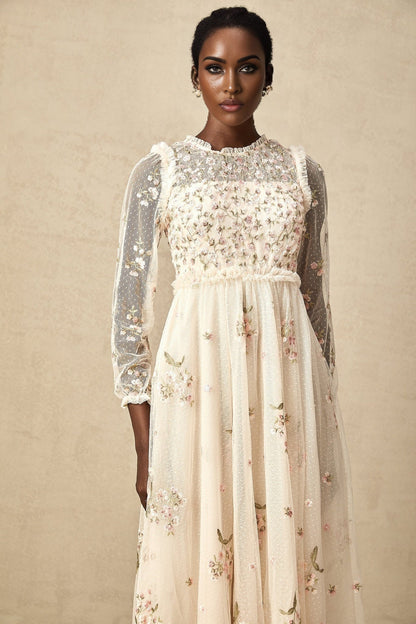 A woman wearing a Celine midi dress made of tulle fabric with delicate floral embroidery details throughout the bodice and skirt