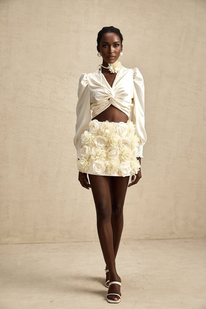 Short white top with twist pattern and decorative artificial flowers