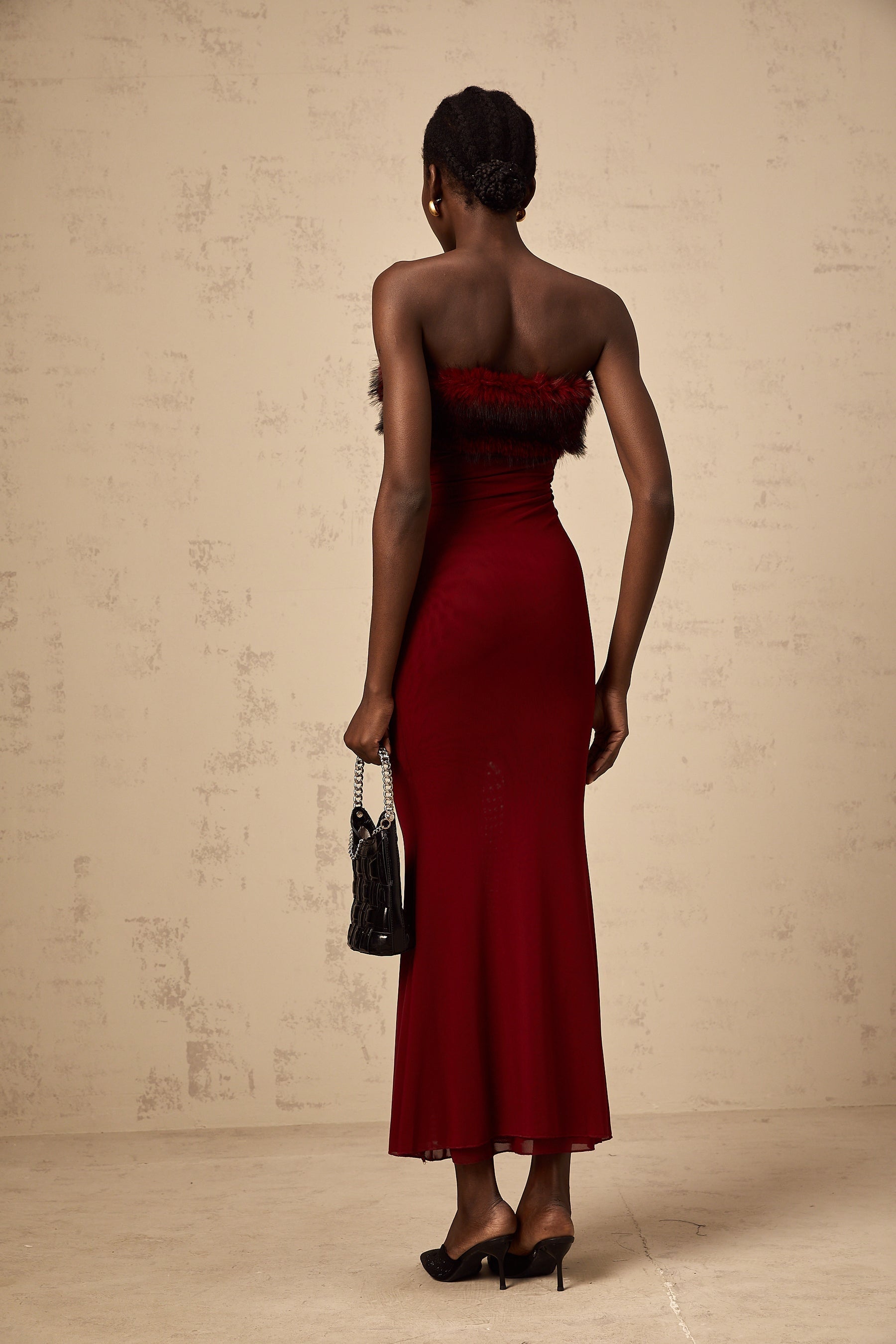 A red offshoulder midi dress with faux fur trim and mesh details featuring a formfitting silhouette