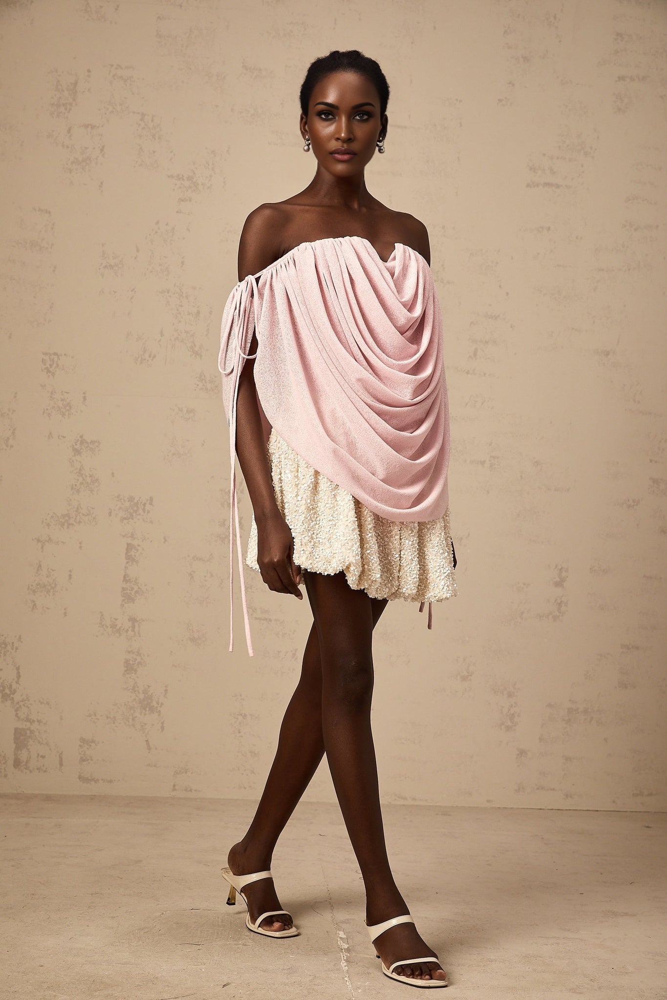 A woman wearing a pink offshoulder top with ruched detailing