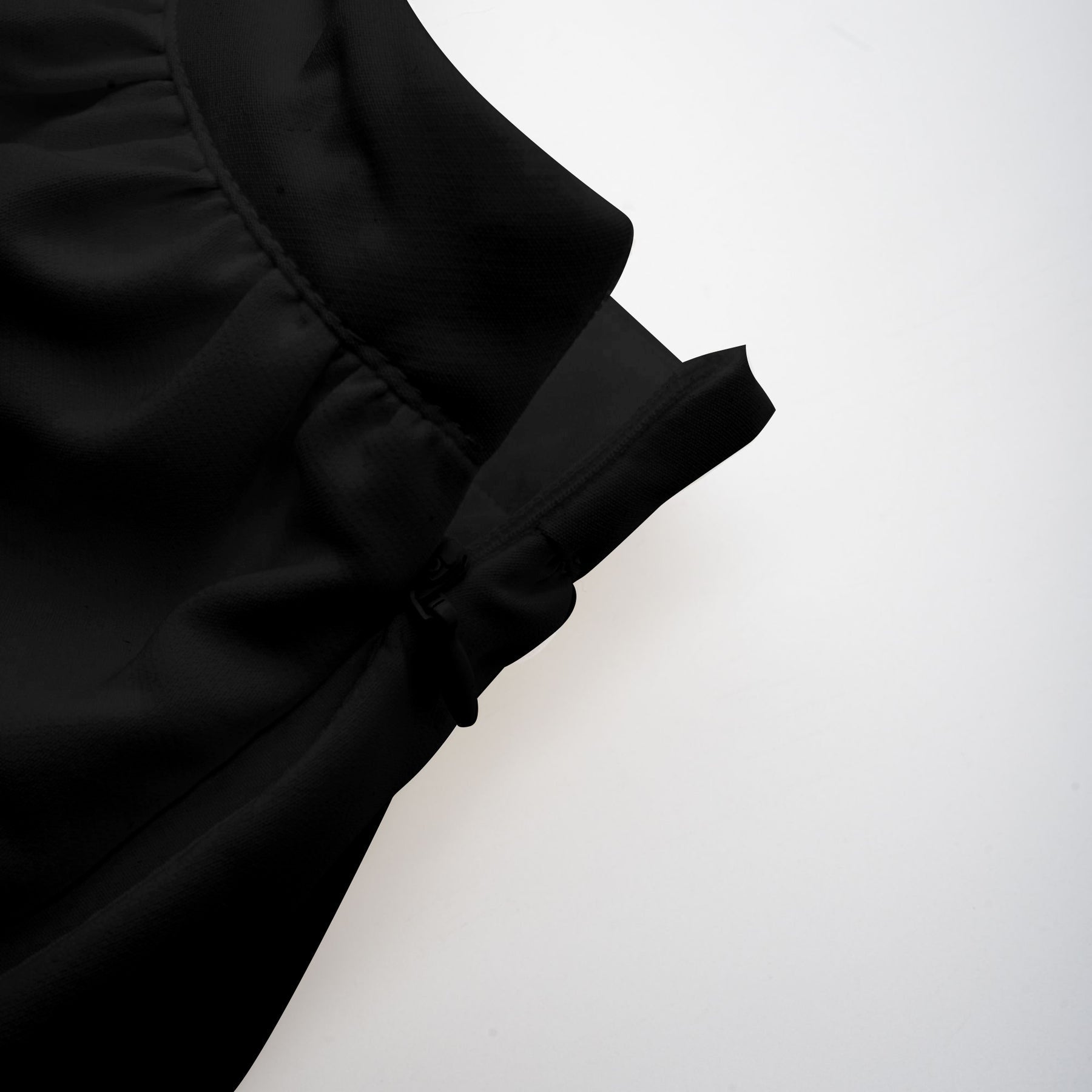 Woman wearing black asymmetric tulle blouse and matching skirt set named Andrea