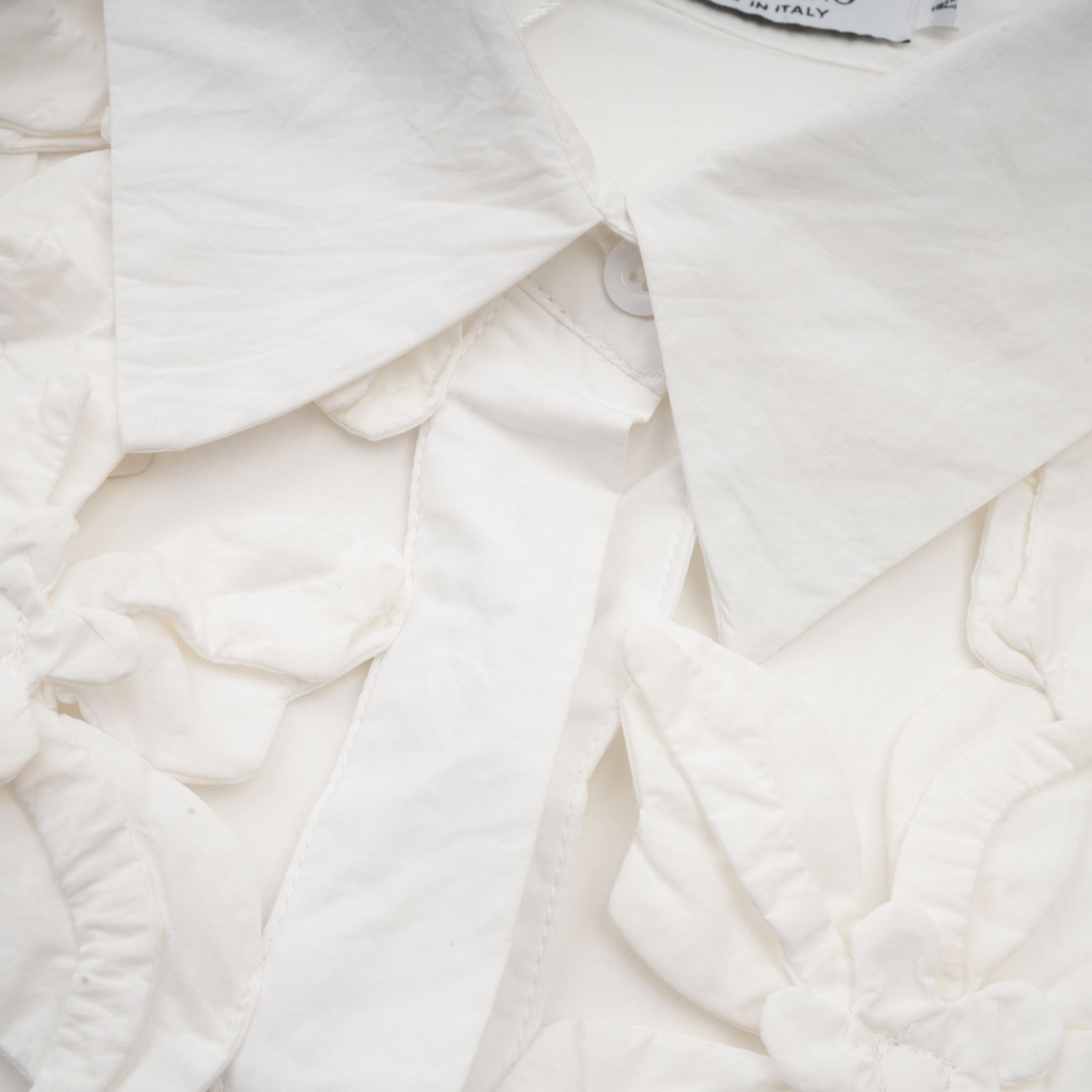 Woman wearing white shirt with floral pattern and cutout details
