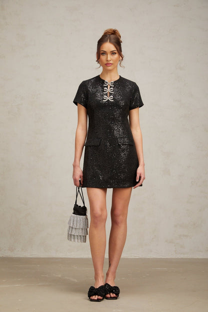 A black mini dress with glitter details and a short hemline