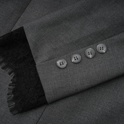 Woman wearing grey blazer with lace panel detailing on sleeves and back